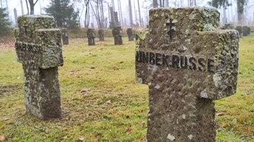 Auf einer Rasenfläche steinerne Grabkreuze mit der Inschrift „unbek. Russe“.