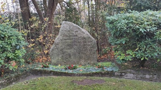 Ein Gedenkstein mit der Inschrift: „Hier ruhen gefallene Soldaten und uns Leben gekommene ausländische Zivilisten des Krieges 1939–1945.“ 